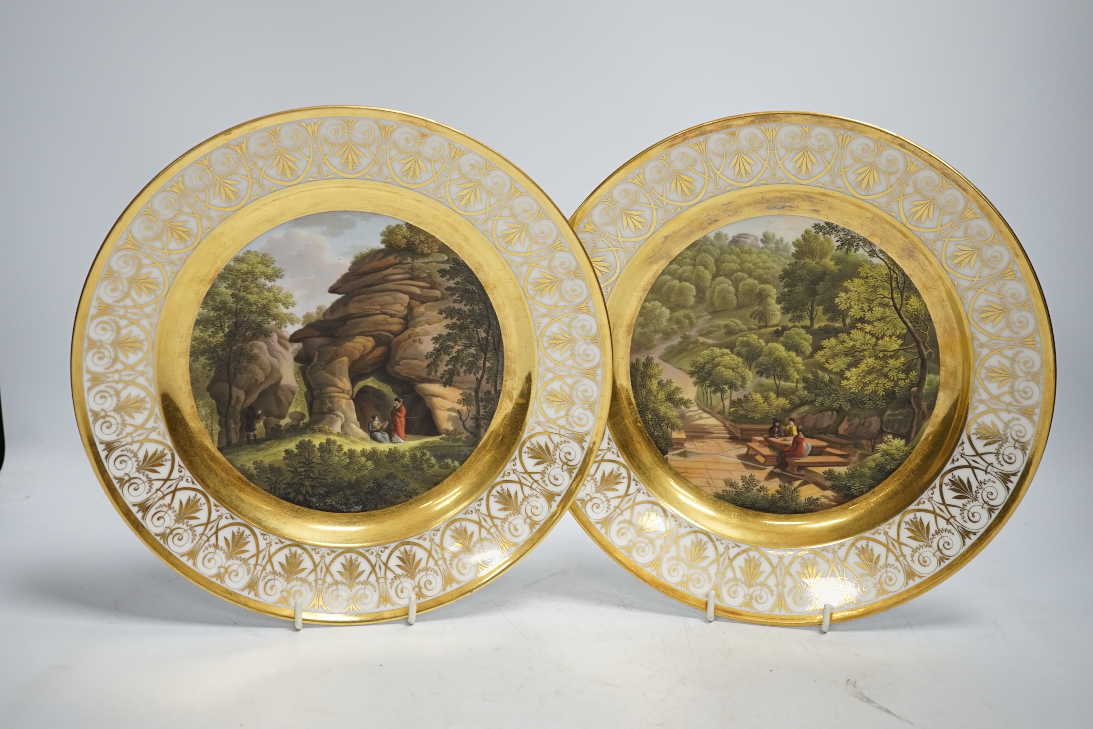 A pair of early 19th century Paris porcelain titled landscape and gilt decorated dishes, 24.5cm diameter